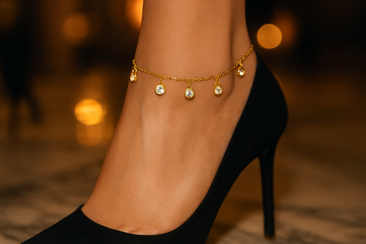 Glamorous lifestyle shot of a white model wearing the gold crystal charm anklet
