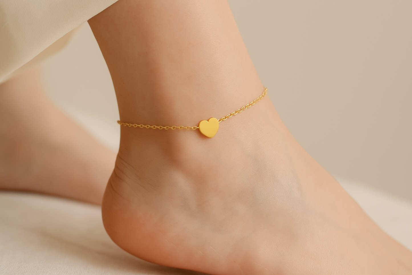 Professional lifestyle photography of a white female model wearing the gold heart anklet